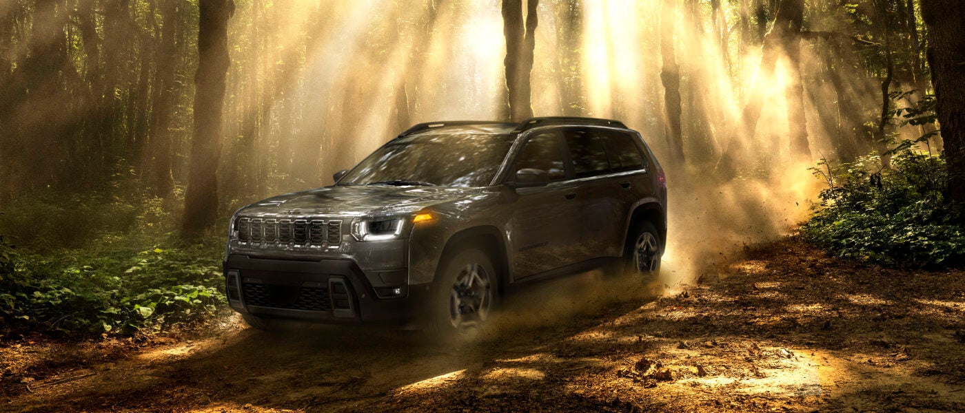 2026 Jeep Cherokee driving in shadowed forest